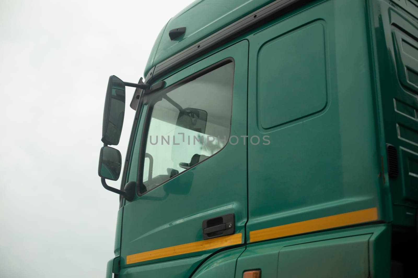 Truck cab on side. Green truck body. Transport details. Rear-view mirror of car. by OlegKopyov