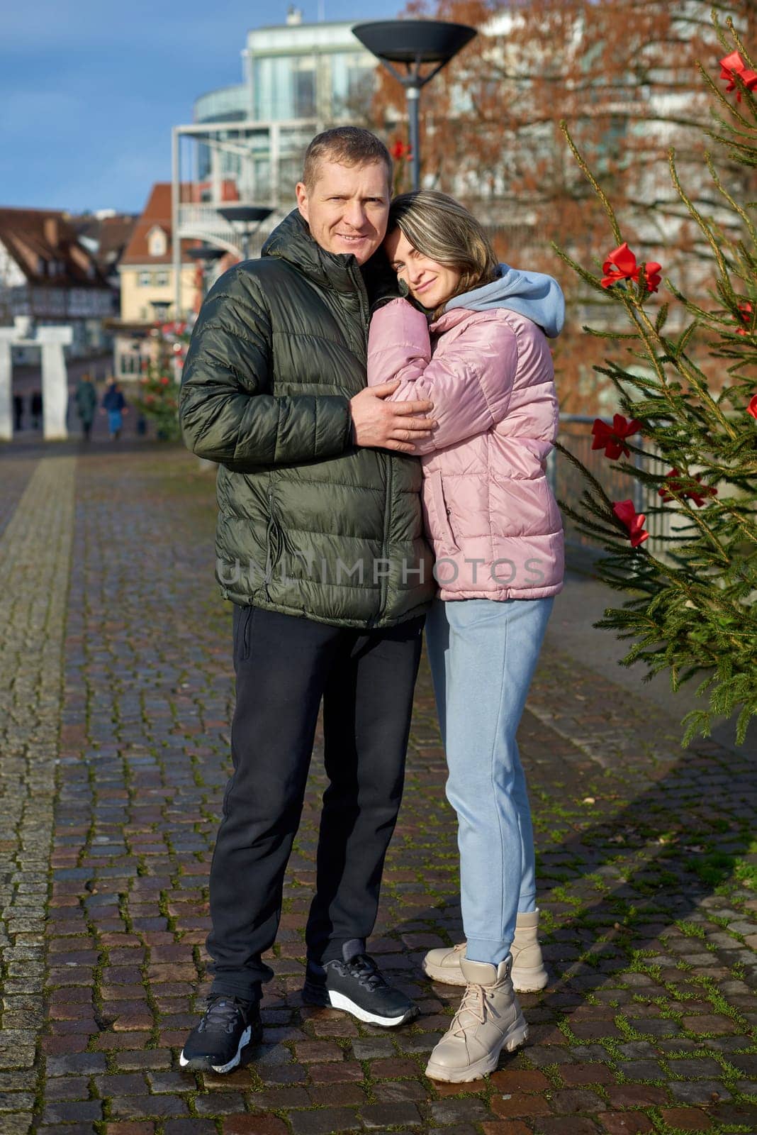 Portrait of young attractive people, lovely couple enjoying cozy atmosphere on fair in Christmas Eve. Spending time together. Concept of national traditions, winter holidays, fashion, festivities