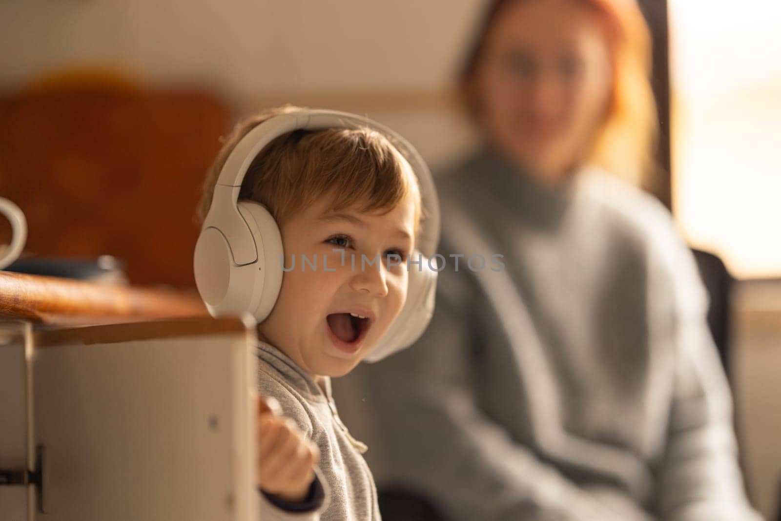 A Boy Listening to Music with a Woman in the Background by Studia72