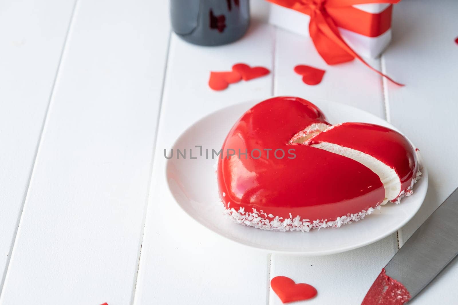 heart shaped glazed valentine cake and flowers on wooden table by Desperada