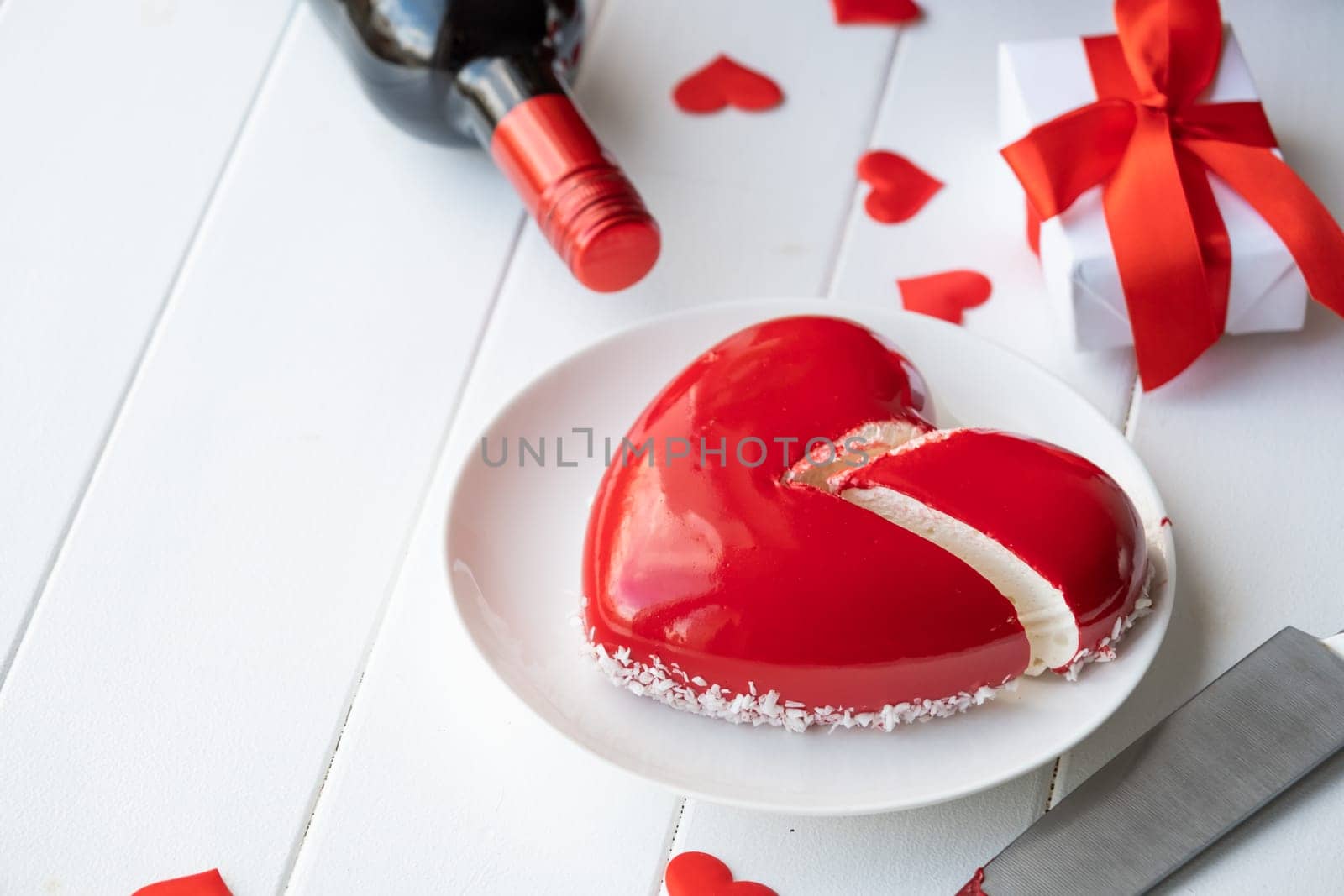 Valentines day. heart shaped glazed valentine cake and flowers on wooden table