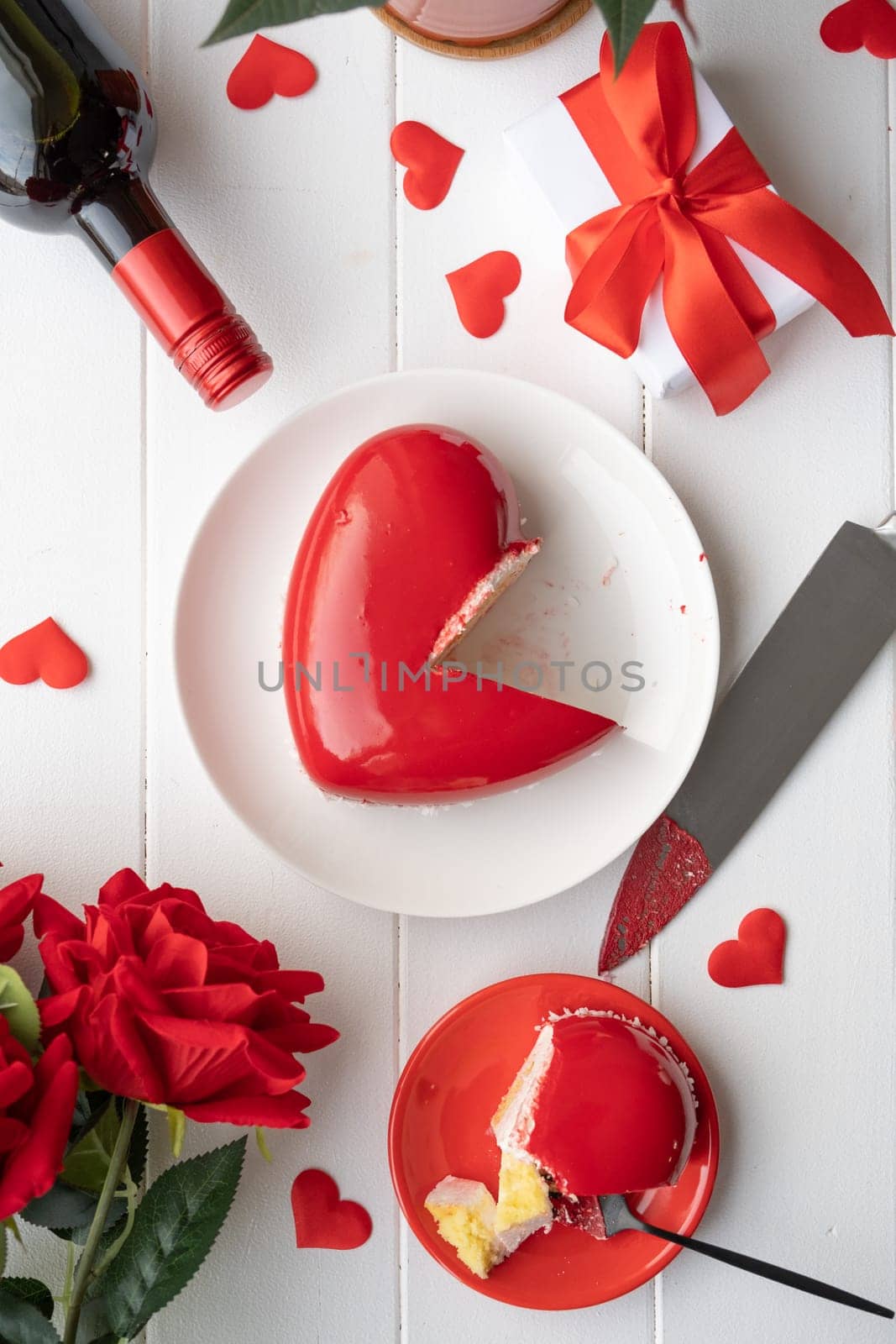 Valentines day. heart shaped glazed valentine cake and flowers on wooden table