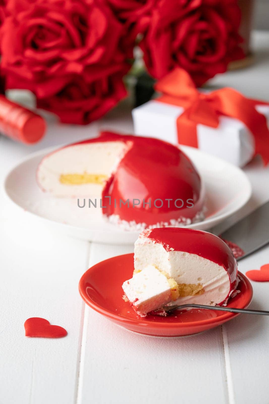 heart shaped glazed valentine cake and flowers on wooden table by Desperada