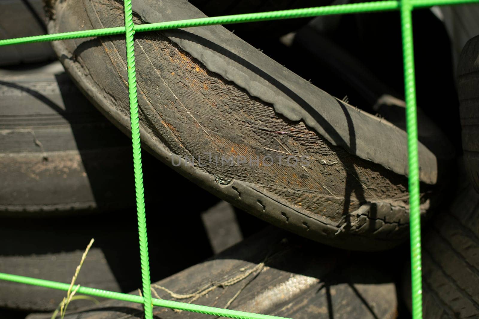 Old tires. Used wheels. Discarded rubber from car. Landfill details. Tire reset mesh.