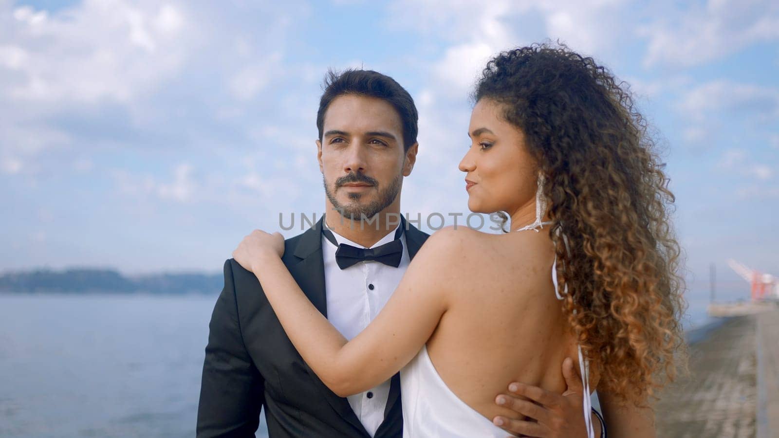 Man in suit with beautiful young woman. Action. Elegant couple in luxurious suits on background of summer landscape. Hot young couple in elegant outfits. Love story.