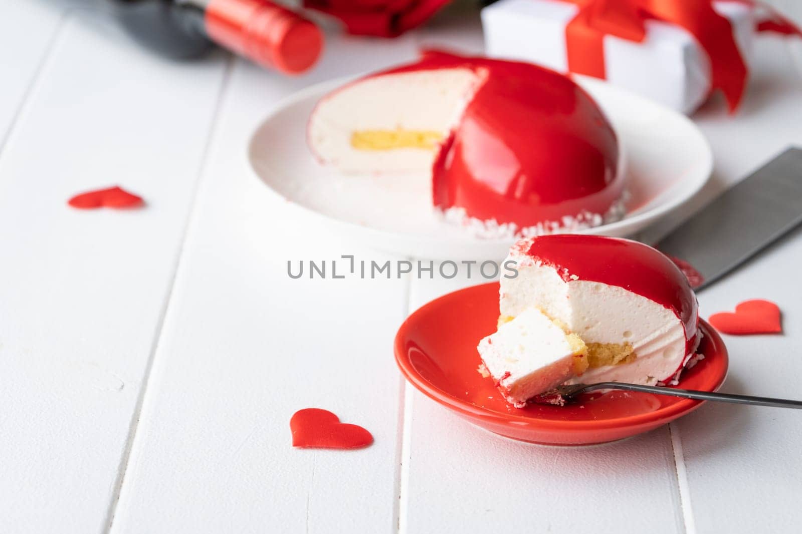 Valentines day. heart shaped glazed valentine cake and flowers on wooden table