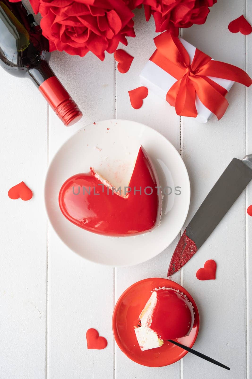 heart shaped glazed valentine cake and flowers on wooden table by Desperada