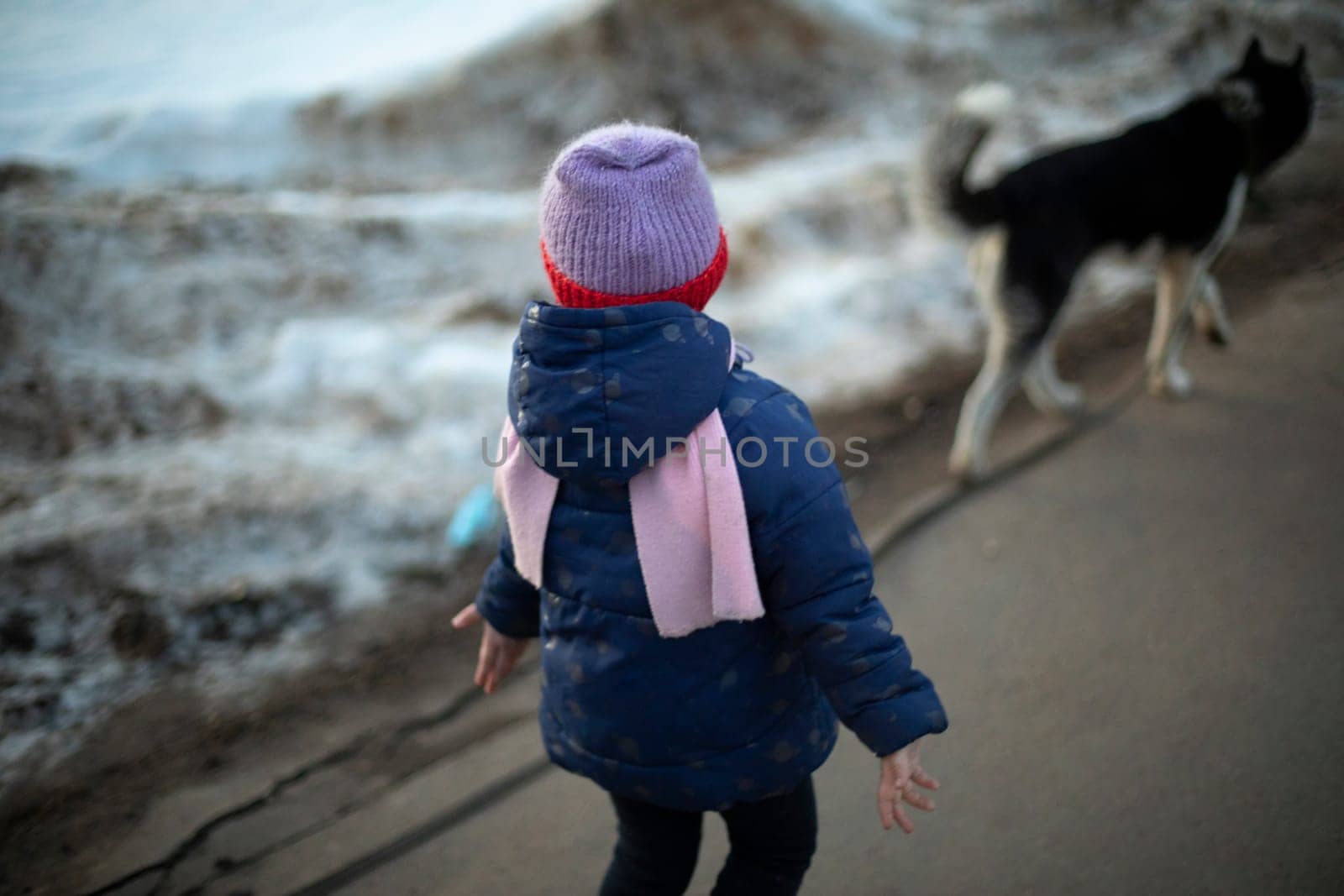 Child in warm clothes. Preschooler walks alone. Child walks down street. Children in urban environment.