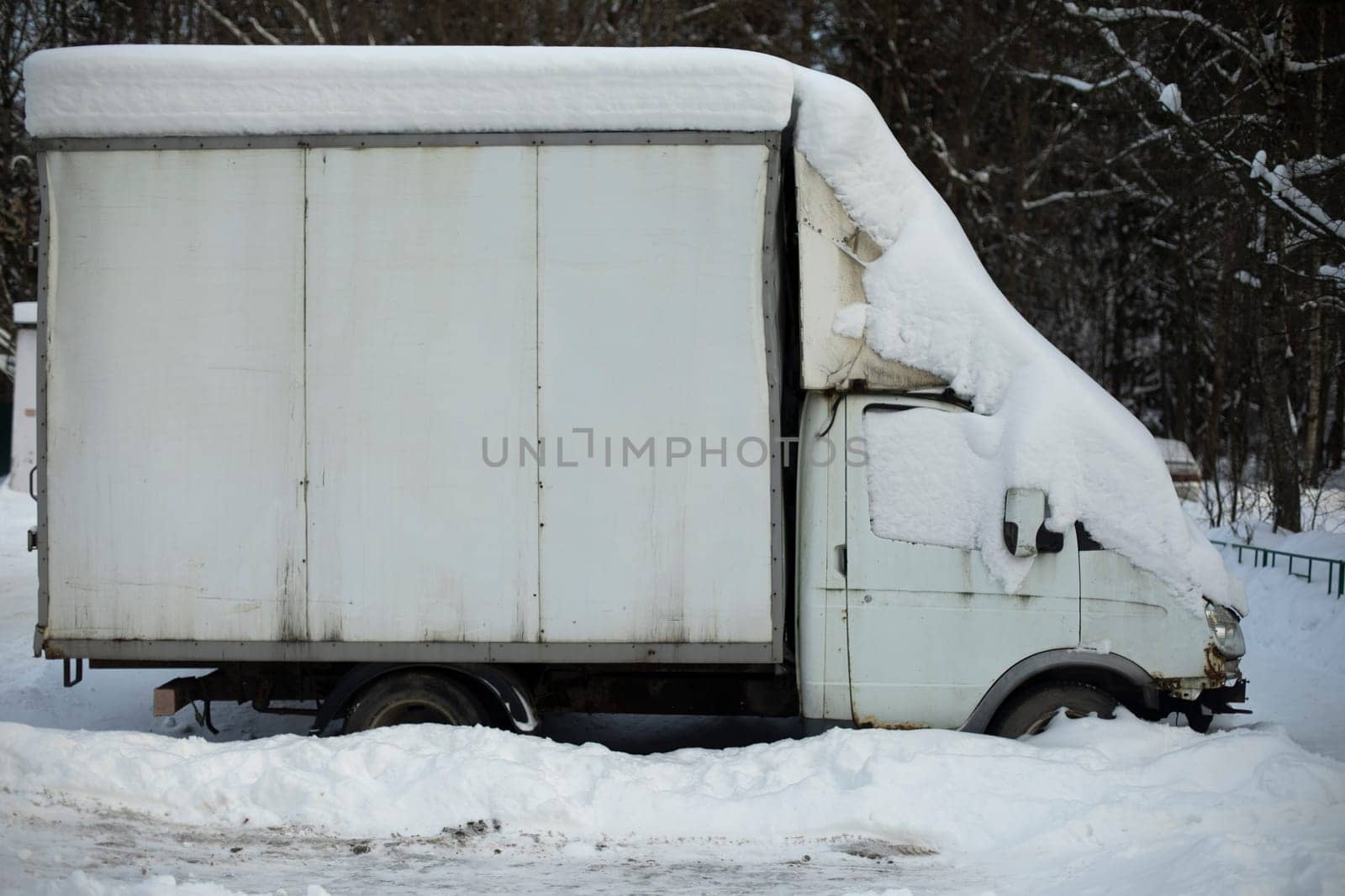 Truck in snow. Car on street. Parking on snow-covered road.