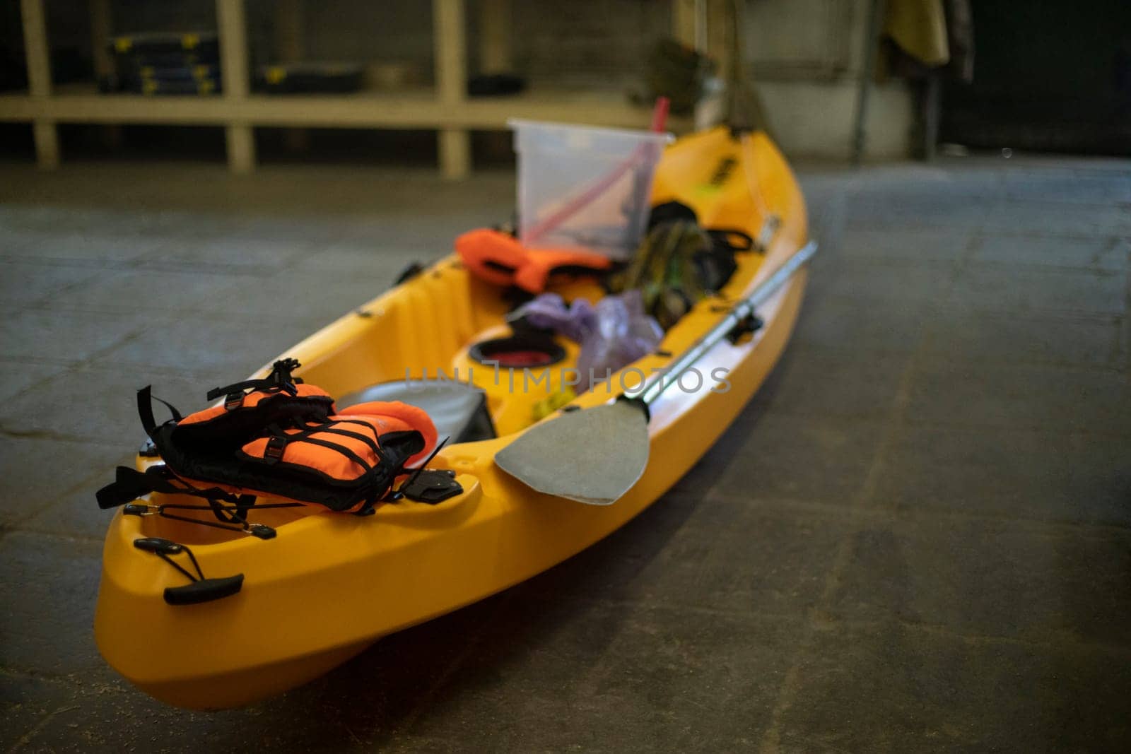 Yellow boat made of plastic. Canoe in garage. Sports equipment. Preparation for hike. by OlegKopyov