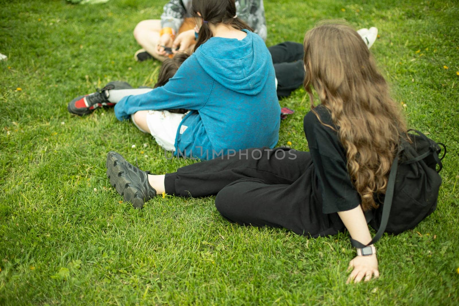 Children in summer relax on green grass. Girls in park. Relax on hot day.