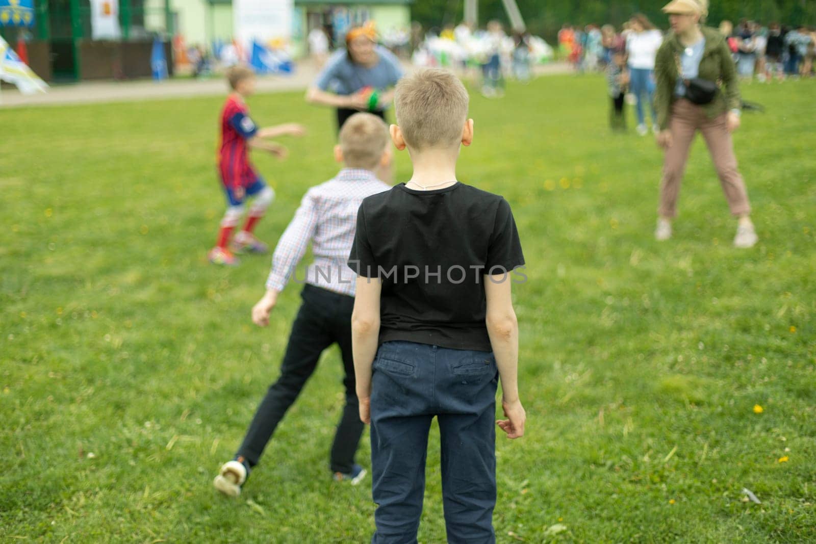 Child on green grass. Schoolboy plays on lawn in summer. Active holidays. by OlegKopyov