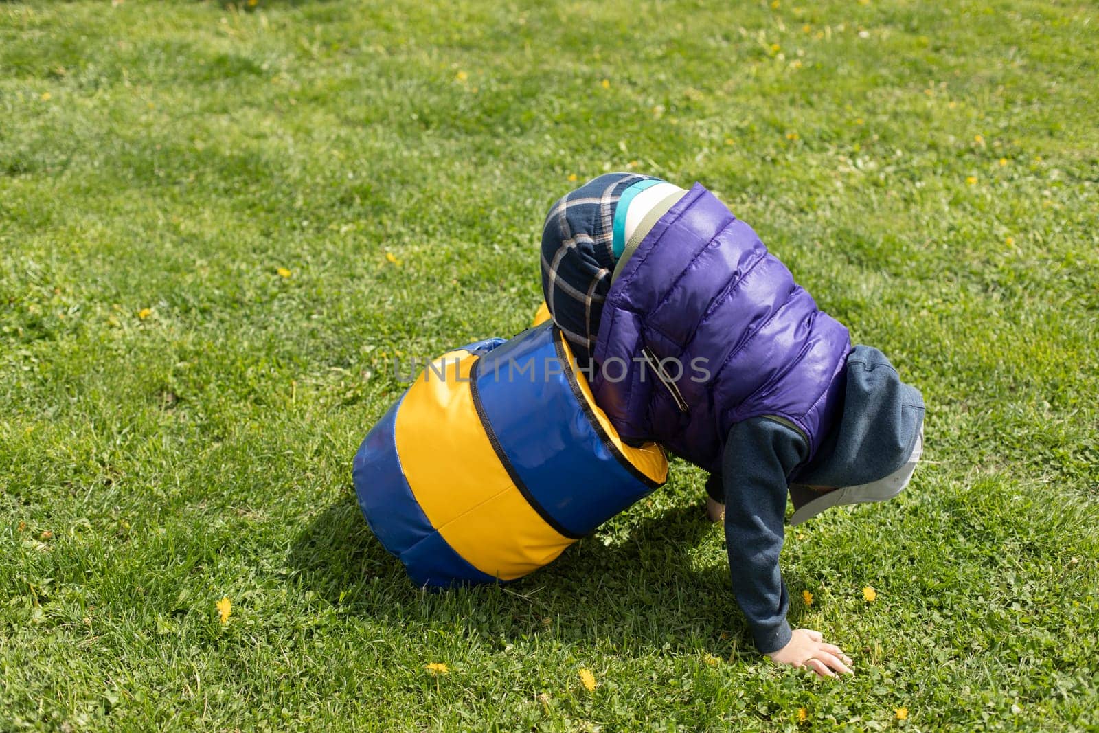 Child plays on green grass. Active lifestyle in summer. Children in park. by OlegKopyov