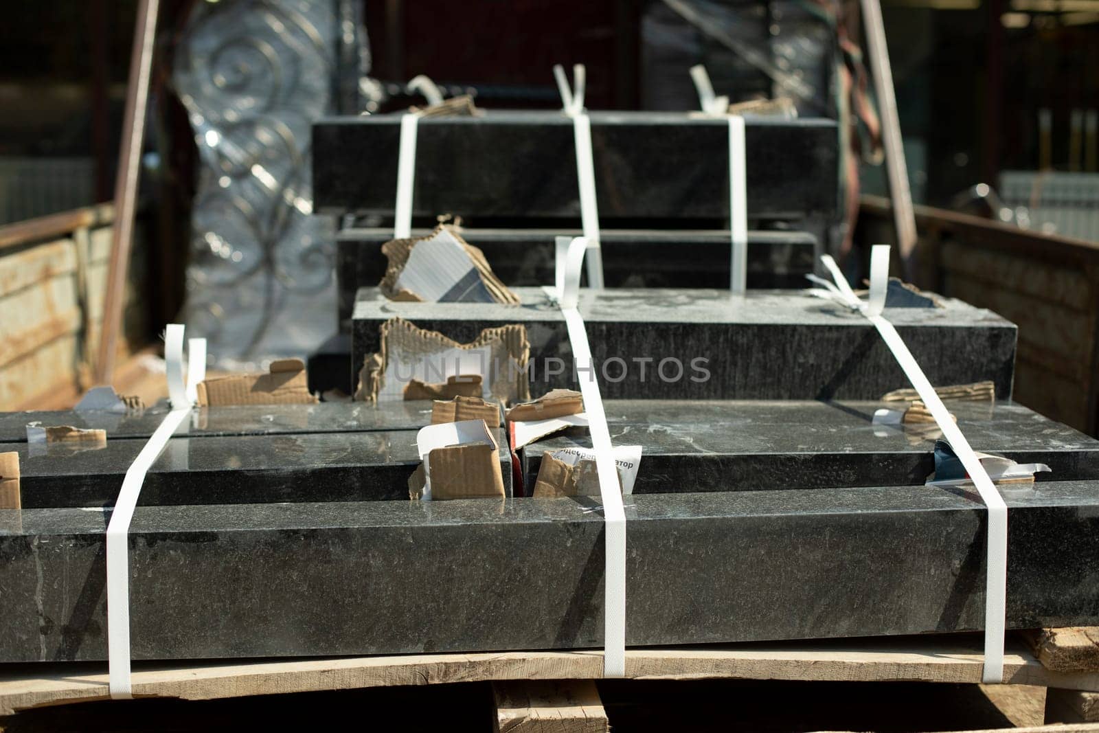 Granite stone in back of truck. Transportation of stone for graves. Details of cargo transportation. Black blocks loaded into truck.