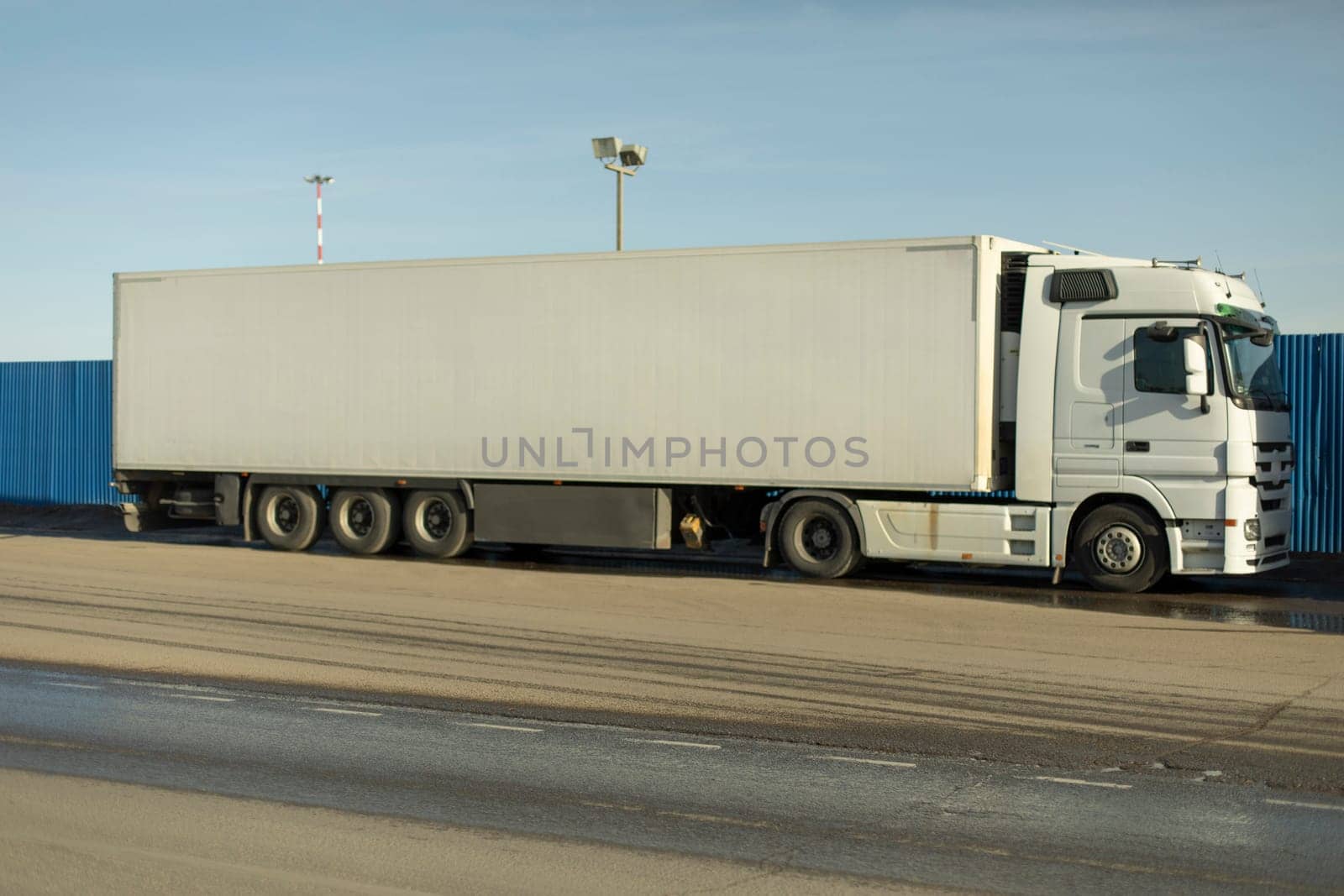 Truck in parking lot. White trailer. Large transport. Truck for transporting goods.