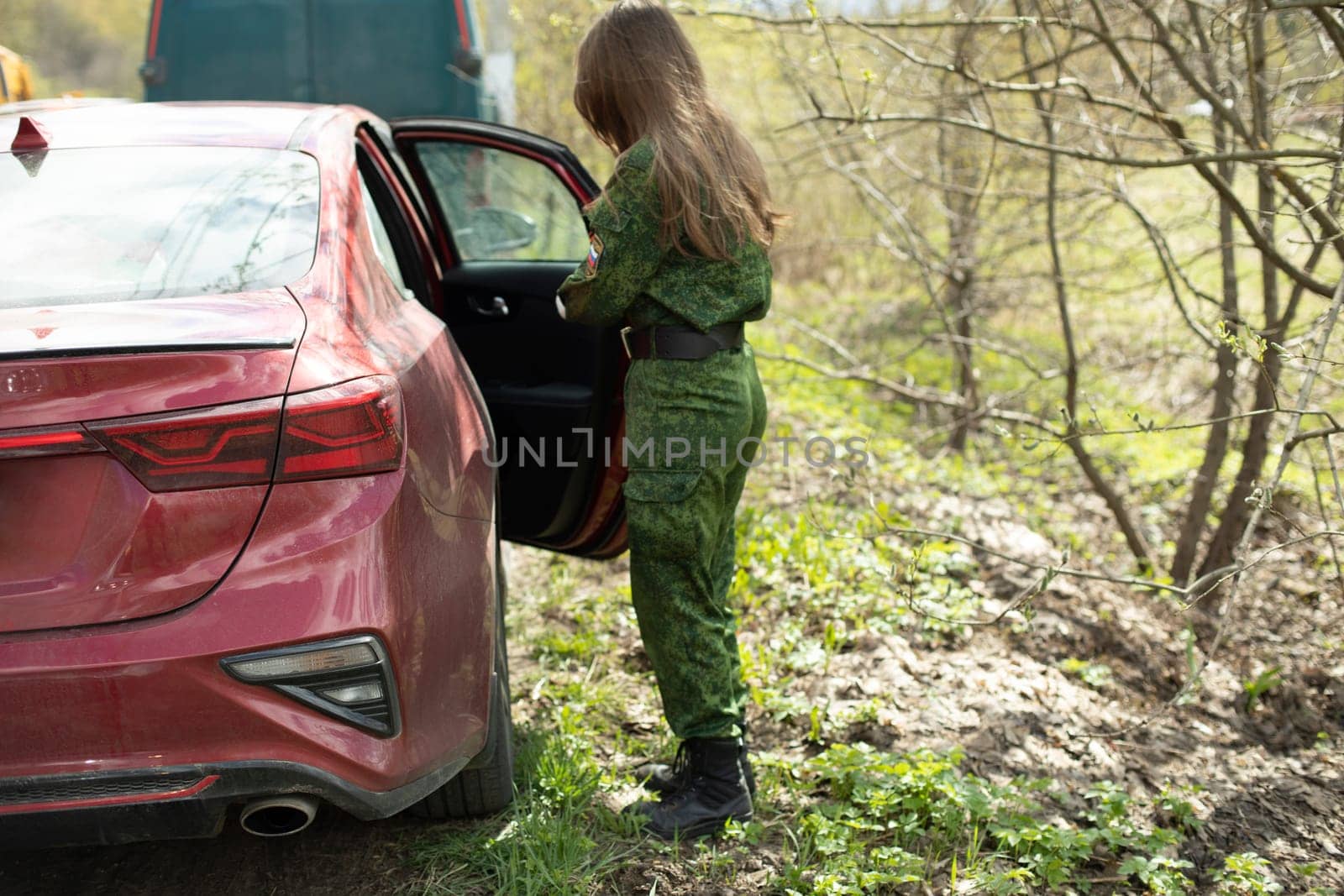 Girl in military uniform gets into car. Girl soldier. Female soldier in Russia. Clothes of military student.