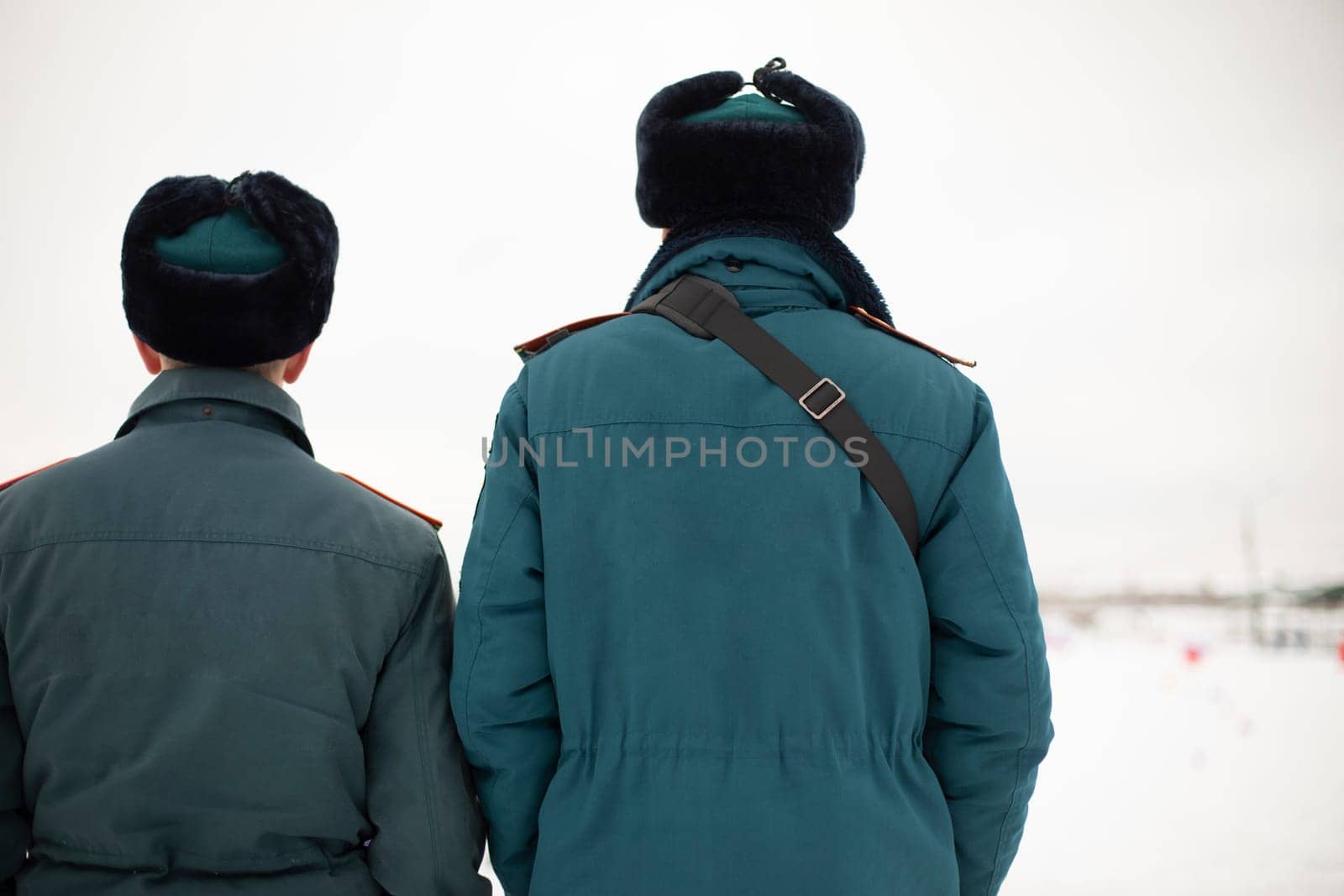 Two rescue workers. Men in uniform. Warm lifeguard uniform in Russia. Two employees guys.