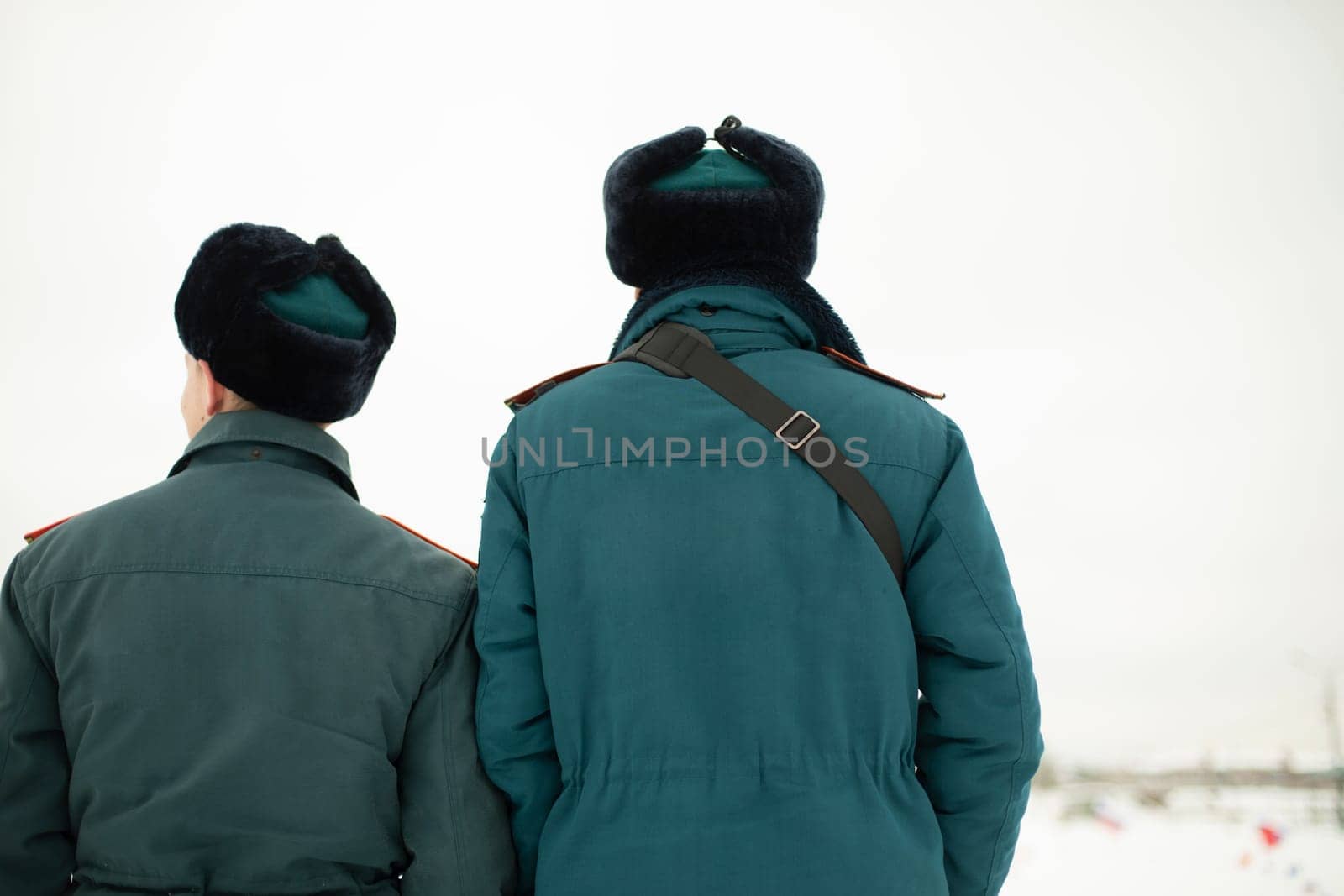 Two rescue workers. Men in uniform. Warm lifeguard uniform in Russia. by OlegKopyov