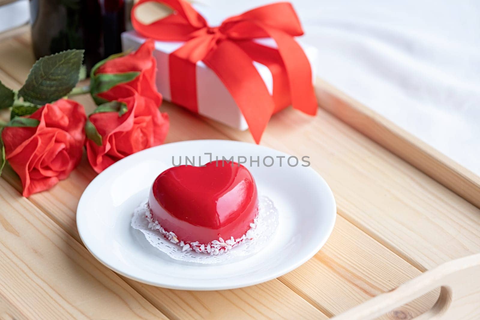 Valentines day. heart shaped glazed valentine cake and flowers in wooden tray