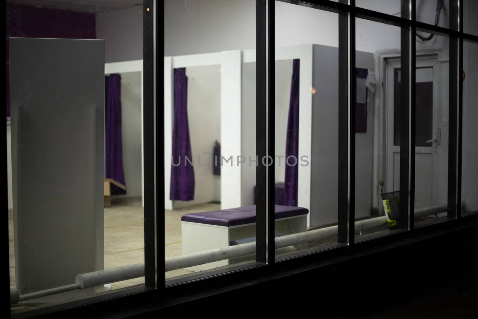 Fitting room in clothing store. Interior of store. Showcase made of glass. Windows inside.