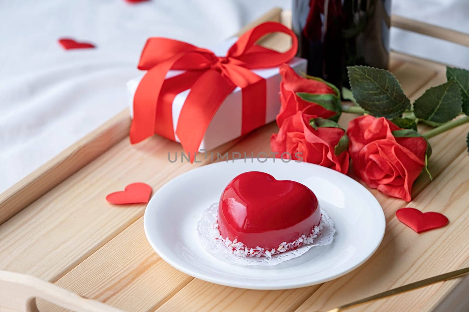 Valentines day. heart shaped glazed valentine cake and flowers in wooden tray