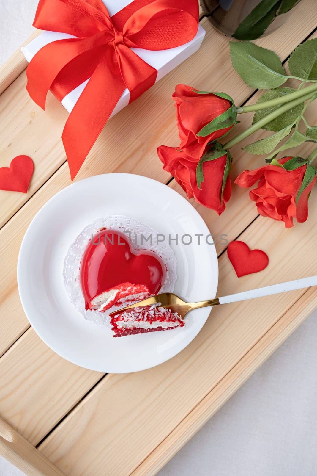 Valentines day. heart shaped glazed valentine cake and flowers in wooden tray