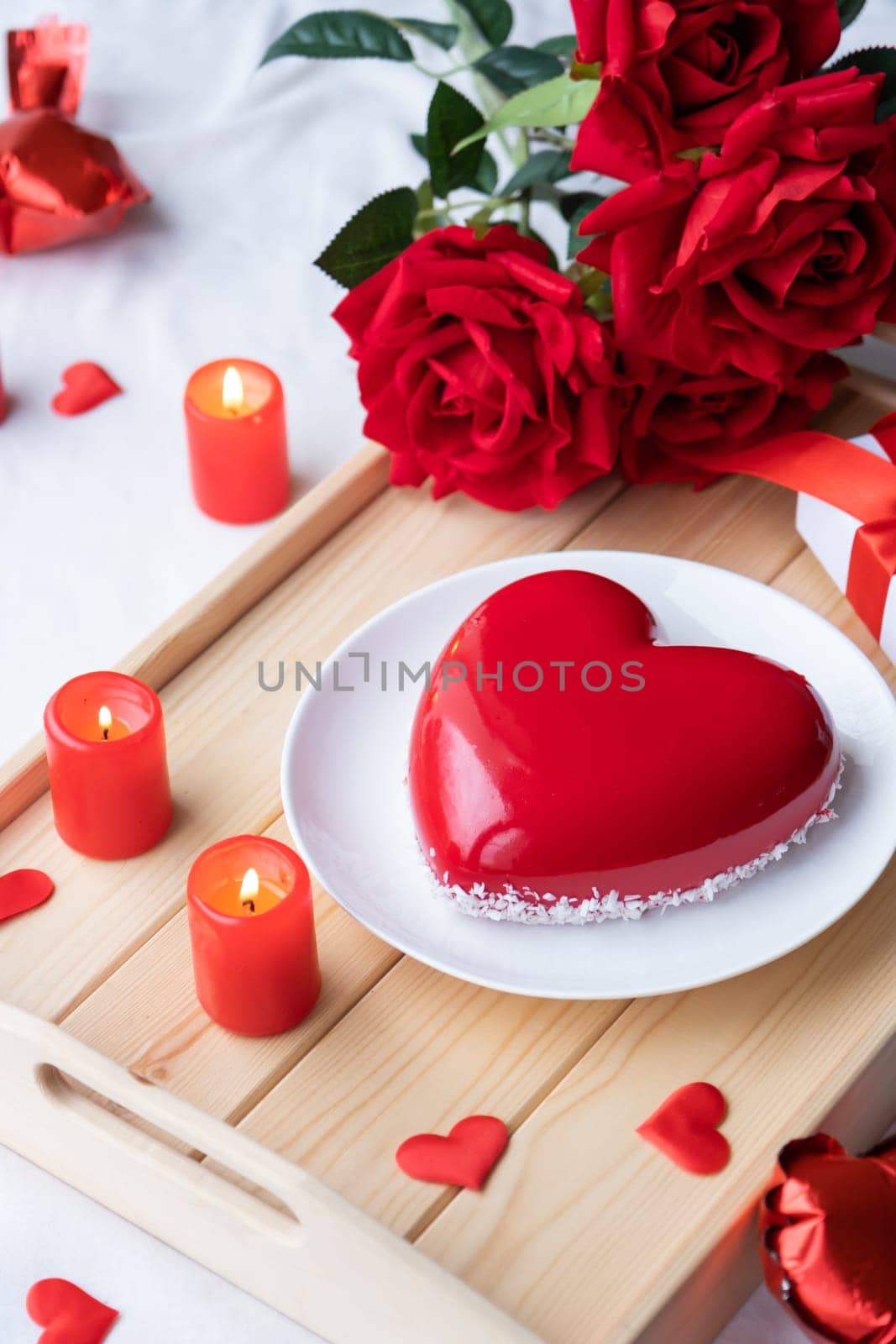 Valentines day. heart shaped glazed valentine cake and candles in wooden tray