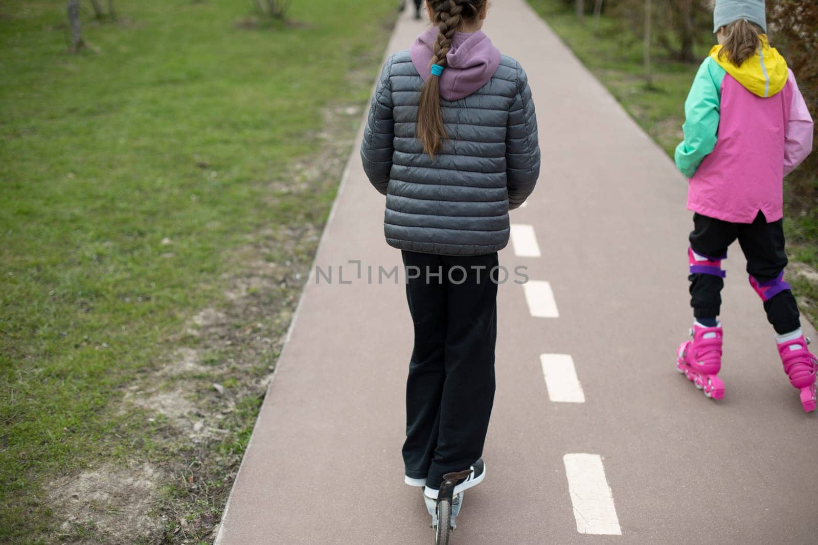 Child on scooter rolls in park. Child on scooter. Walk with children in city. by OlegKopyov