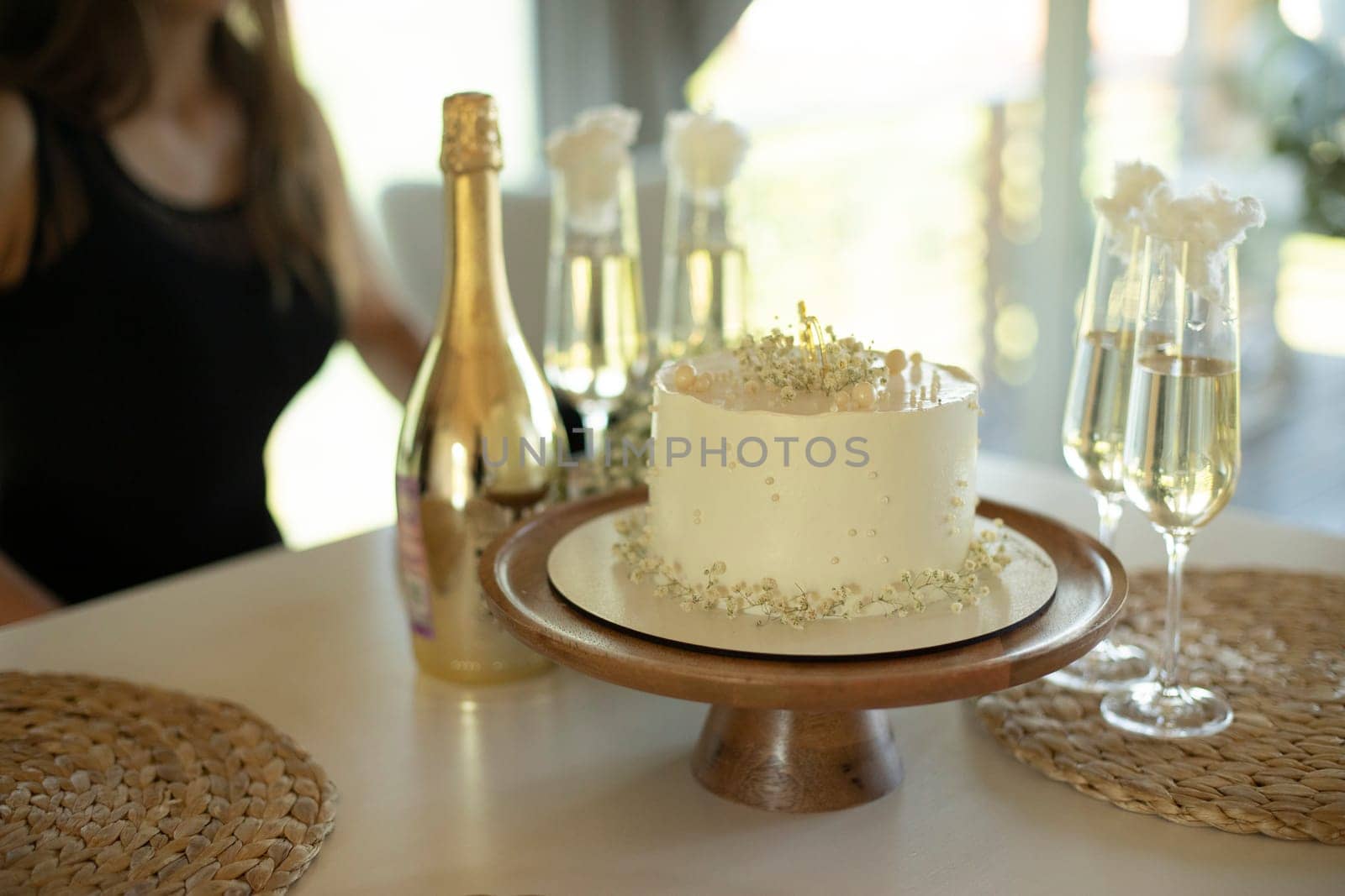 White cake. Sweet cake and glasses of champagne. Cake on table. Refreshments for guests. Details of celebration.