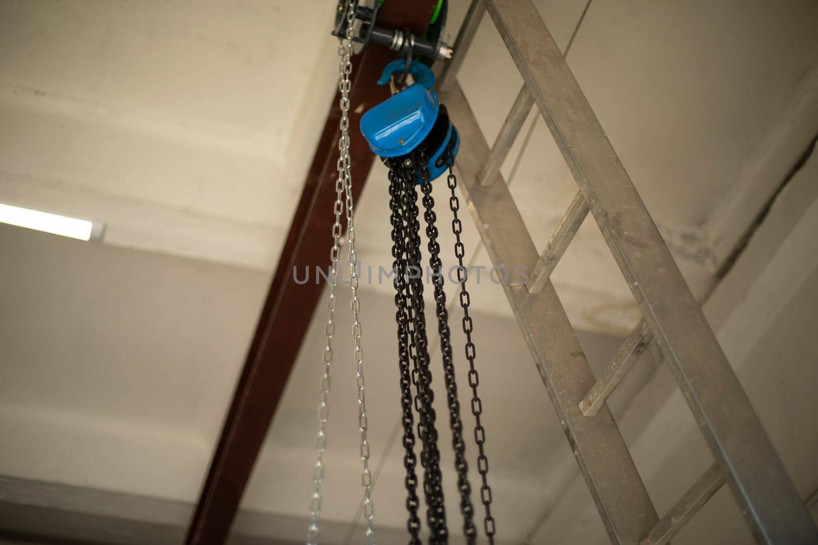 Chain on ceiling. Chains hang on steel beam. by OlegKopyov