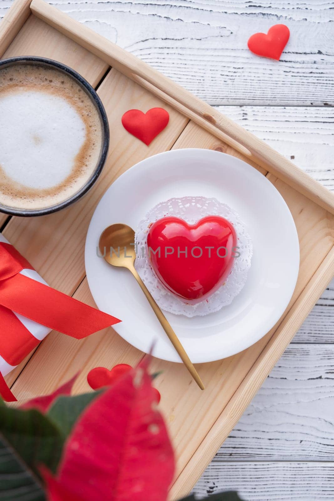 Valentines day. heart shaped glazed valentine cake and flowers in bed