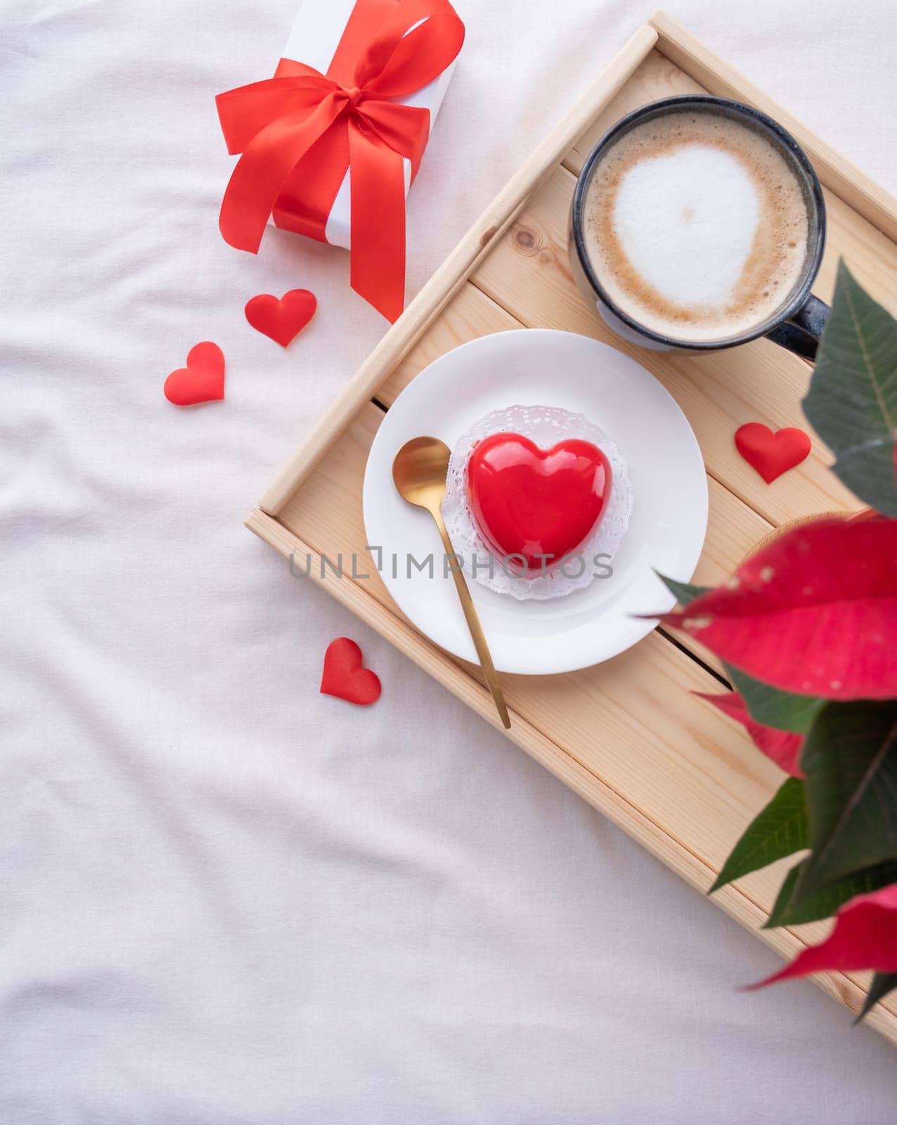 Valentines day. heart shaped glazed valentine cake and flowers in bed