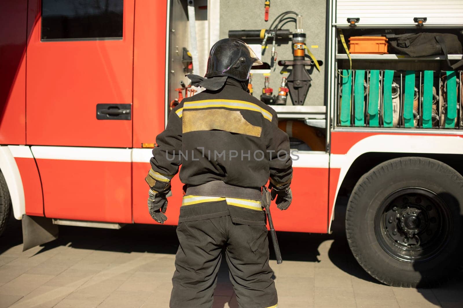 Firefighter at work. Lifeguard near car. Fire service vehicle.