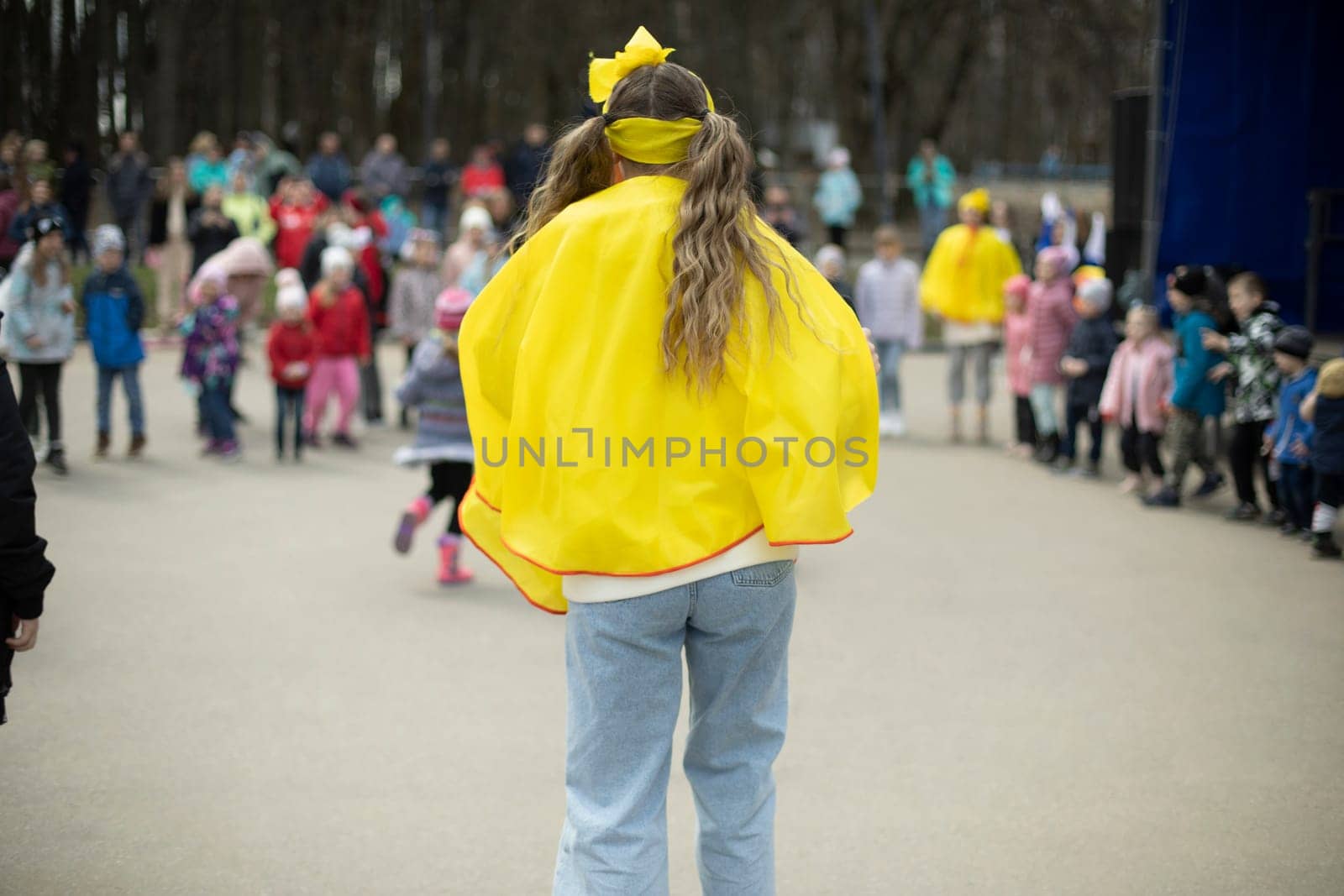 Girl entertains children in square. City holiday in park. by OlegKopyov