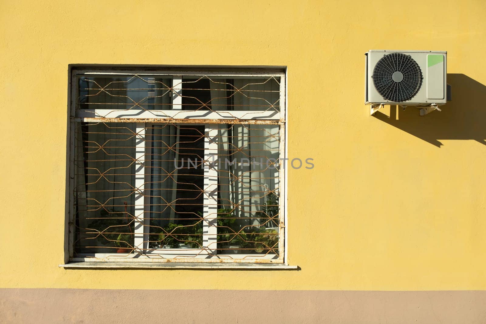 Window and air conditioning. Window in building outside. Architecture details. Grille on window.