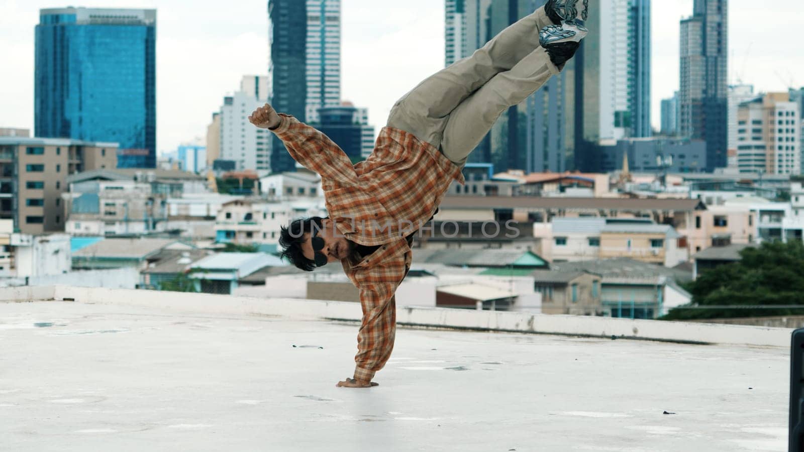 Professional hispanic break dancer practice B boy dance while multicultural friends at roof top with cityscape, urban. Young modern dancing group doing hip hop movement. Outdoor sport 2024. Endeavor.