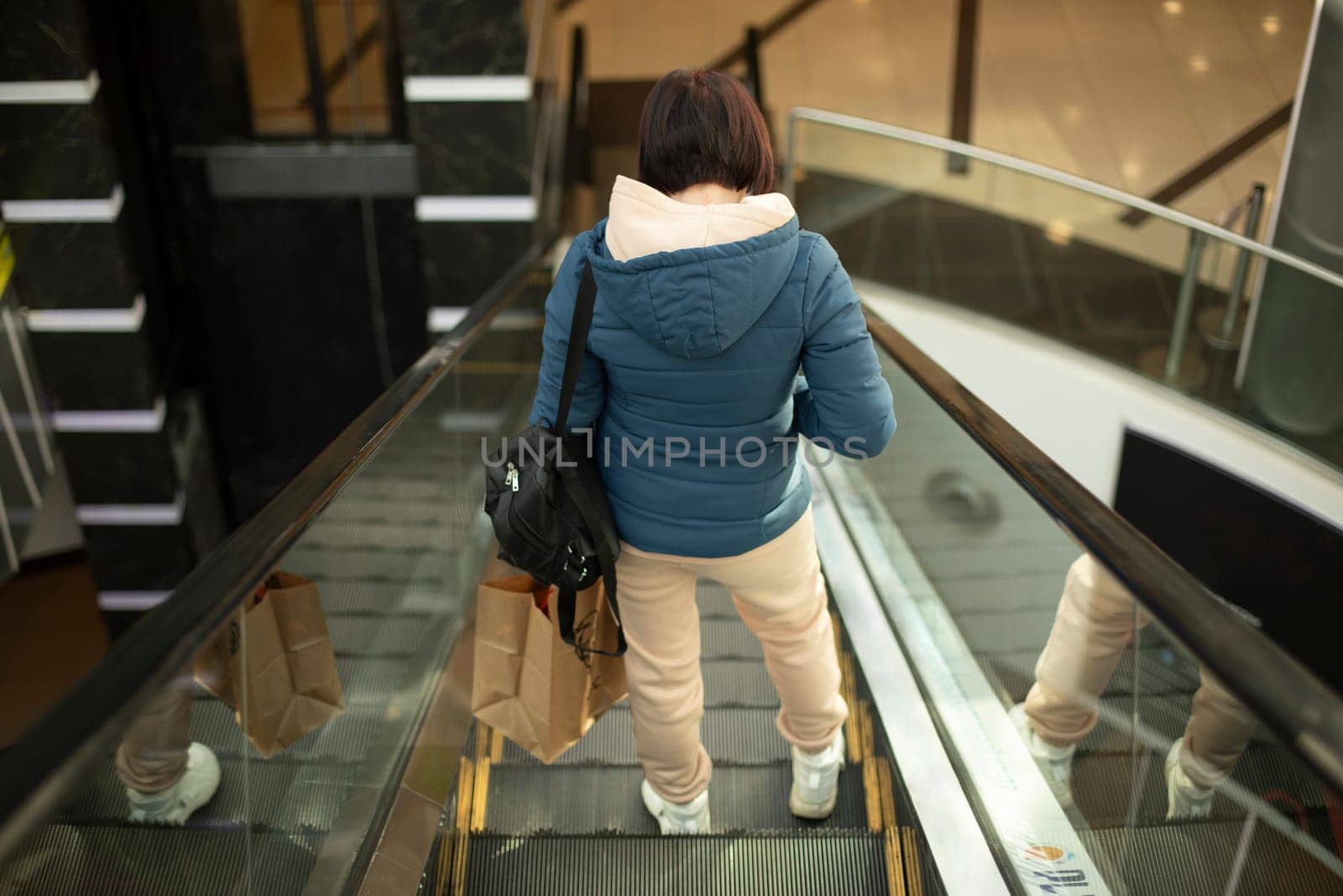 Girl in shopping mall on lift. Girl on stairs. Interior of office building. by OlegKopyov