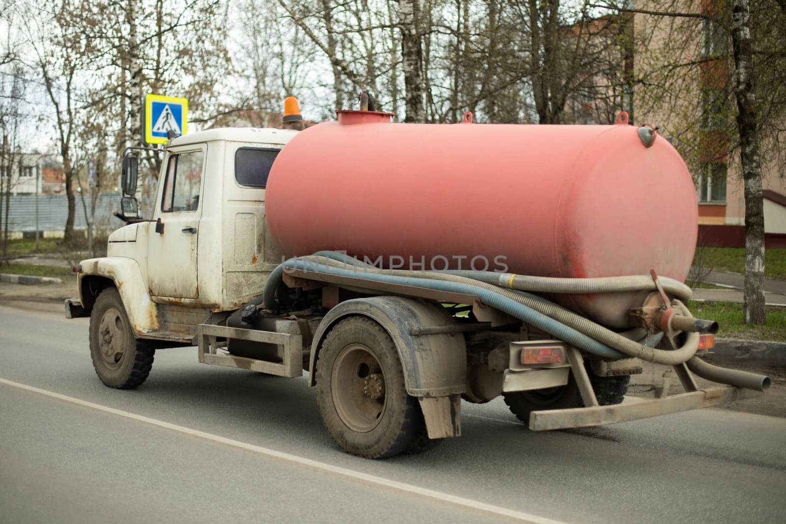 Car for pumping out sewers. Truck with tank. Old technique for pumping out feces. Truck on road.