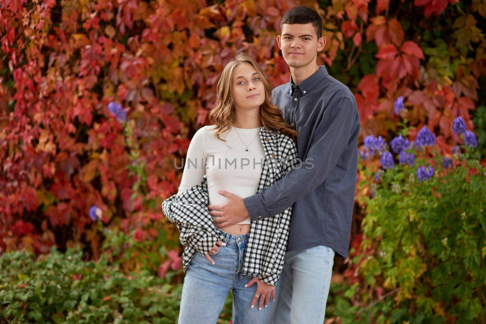 Young Cute Female Hugs Boyfriend. In Autumn Outdoor. Lovers Walking in Park. Attractive Funny Couple. Lovestory in Forest. Man and Woman. Cute Lovers in the Park. Family Concept. Happy Couple.