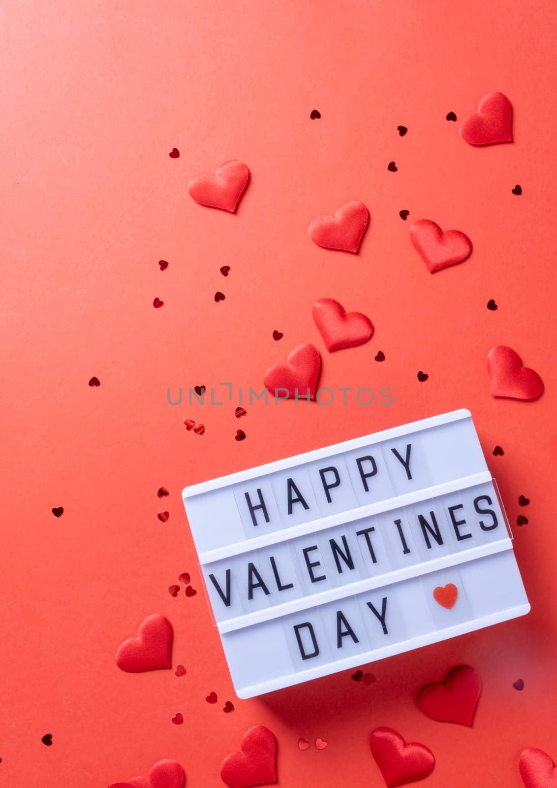 Valentines day. letter board with words Happy Valentines Day an heart shape confetti on red background