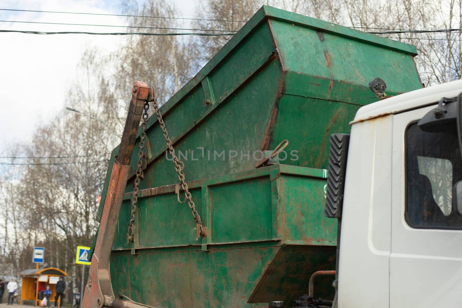 Transportation of container. Garbage truck. Steel container on transporter.