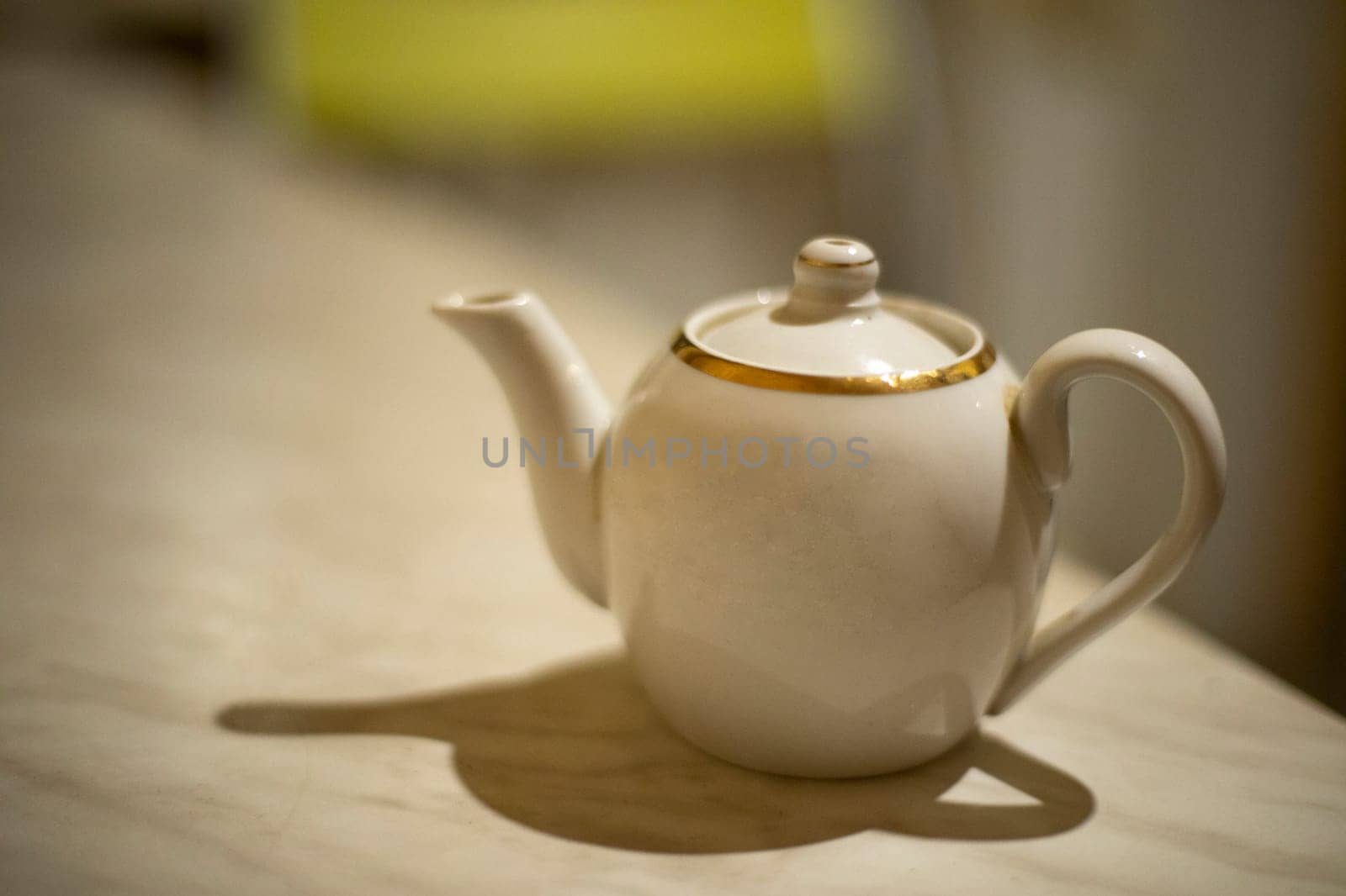 Kettle on table. Teapot in kitchen. White dishes.