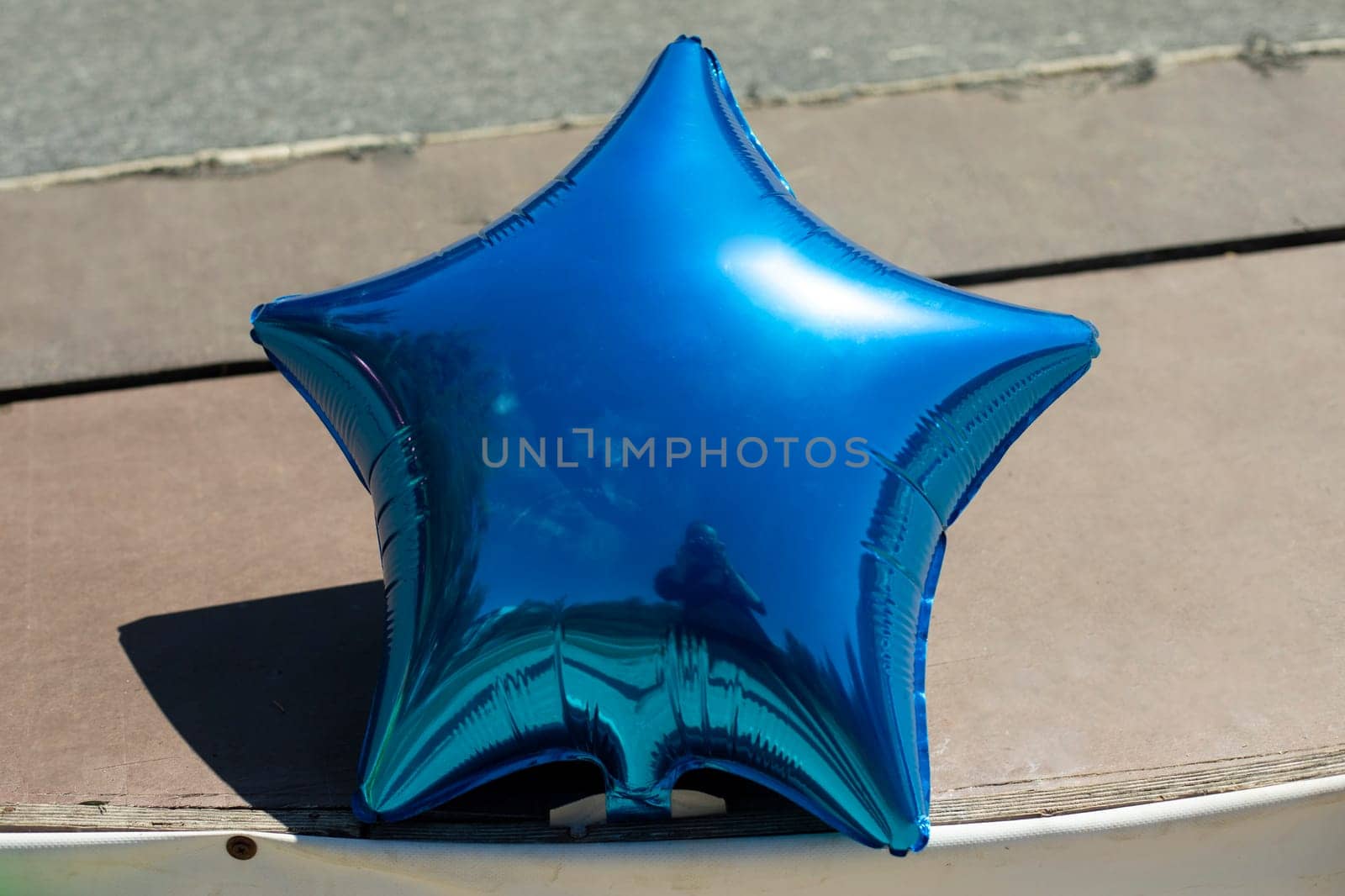 Blue star is inflatable ball. Decoration of inflatable balloon in shape of star. Details of festive exterior.