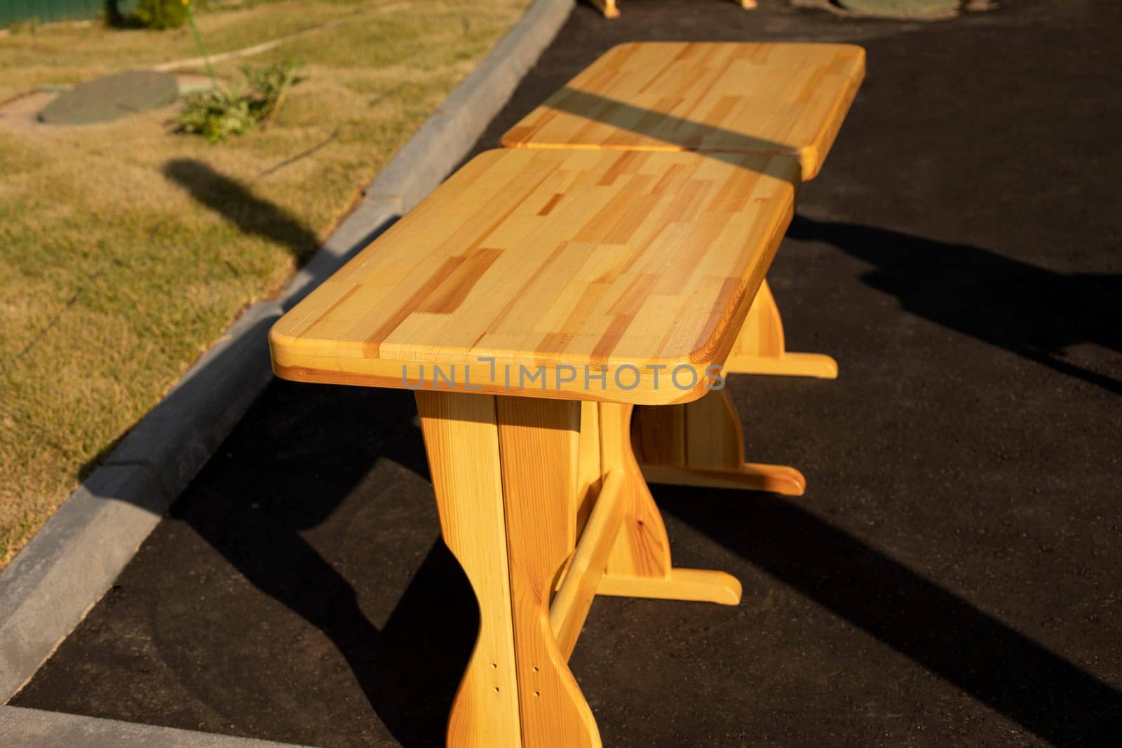 Wooden shop on street. Bench for sitting. Furniture in sunlight. Wooden product.