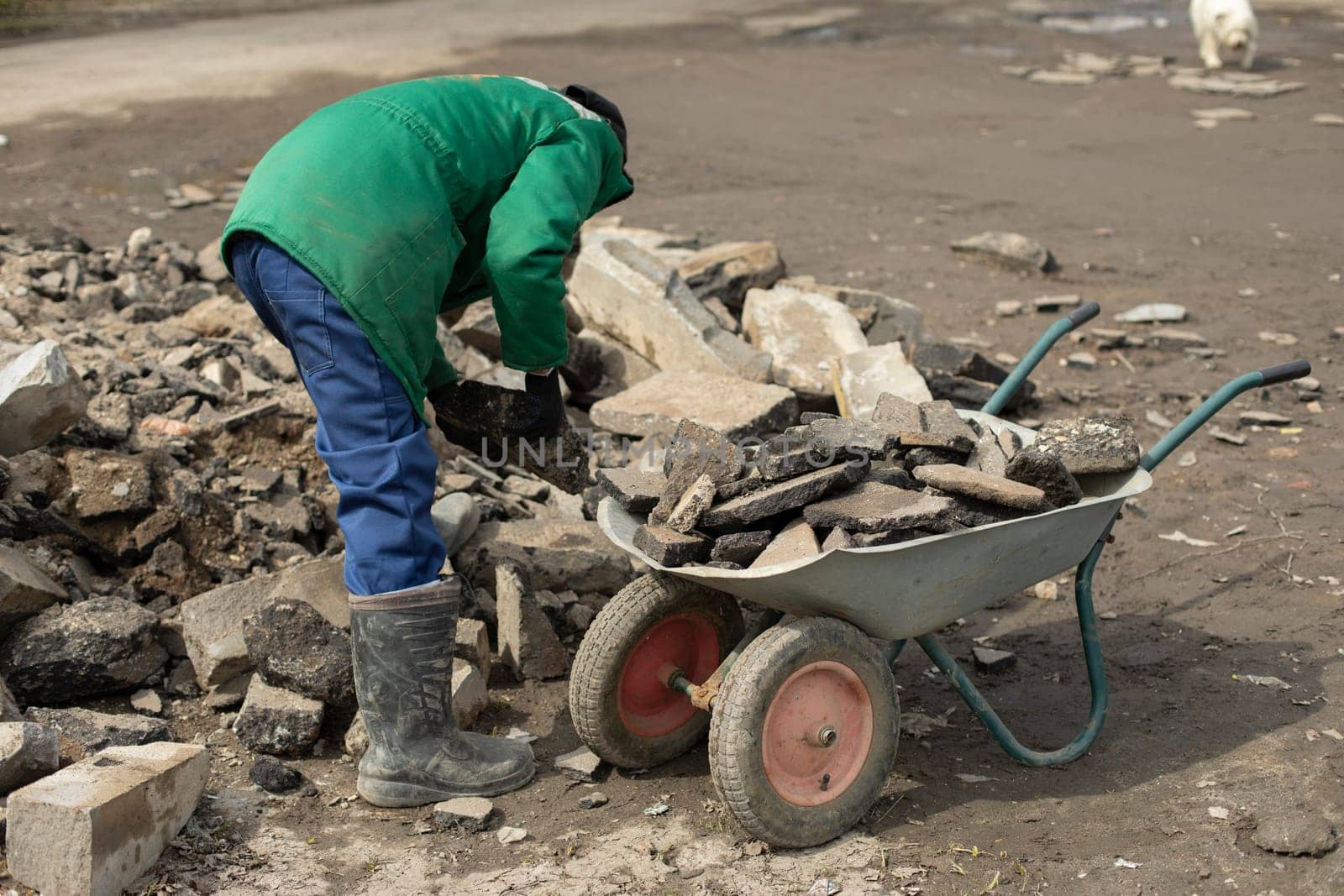 Transportation of broken stone. Worker dismantles block of stones. by OlegKopyov