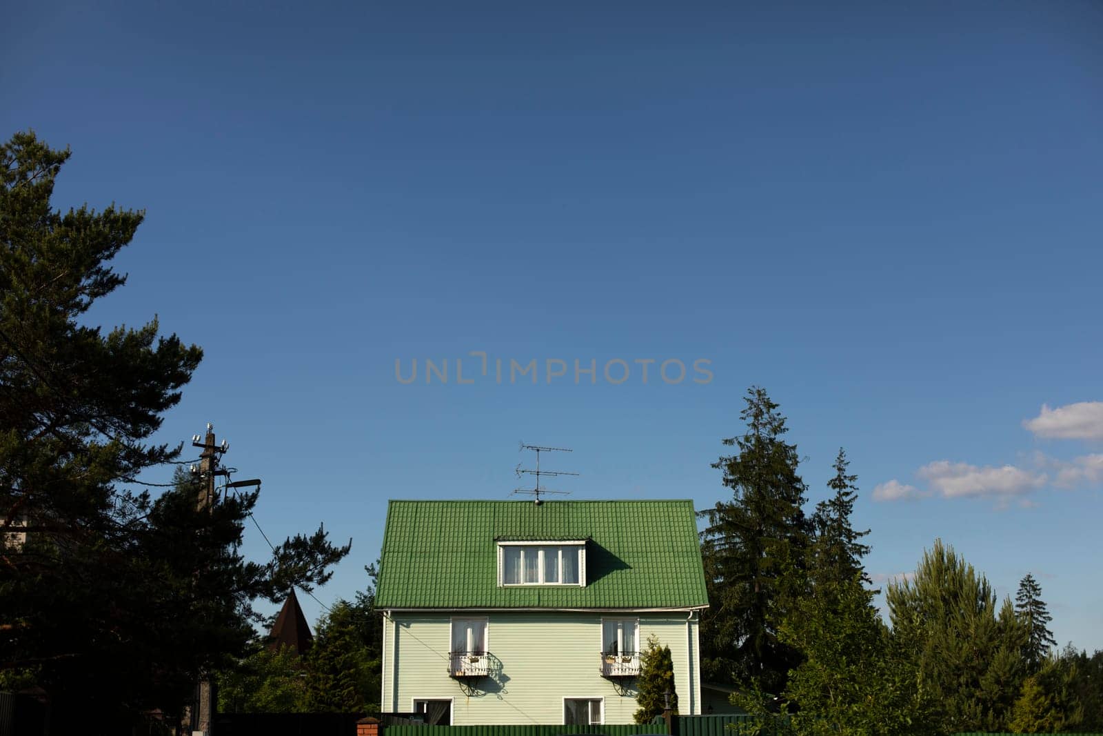 House with green roof in countryside. Country house in forest. Beautiful manor. Stone house outside city.