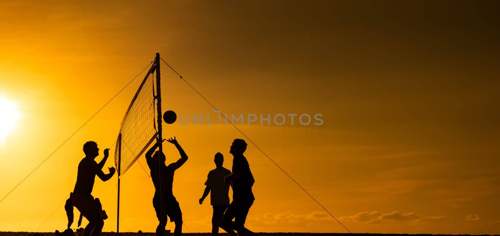 People Playing Volleyball by the Ocean at Sunset by Studia72