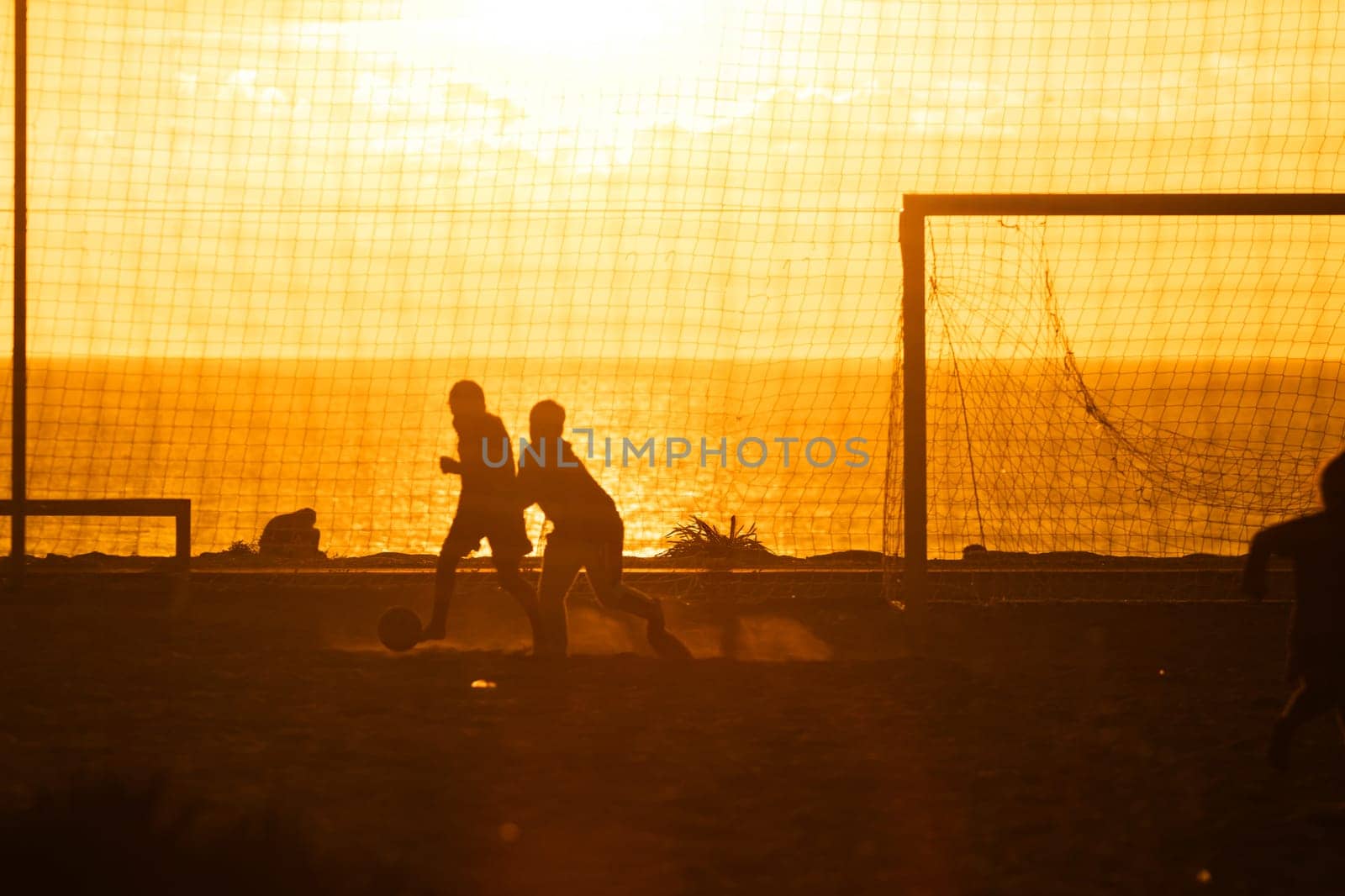 A couple of people standing next to a soccer goal
