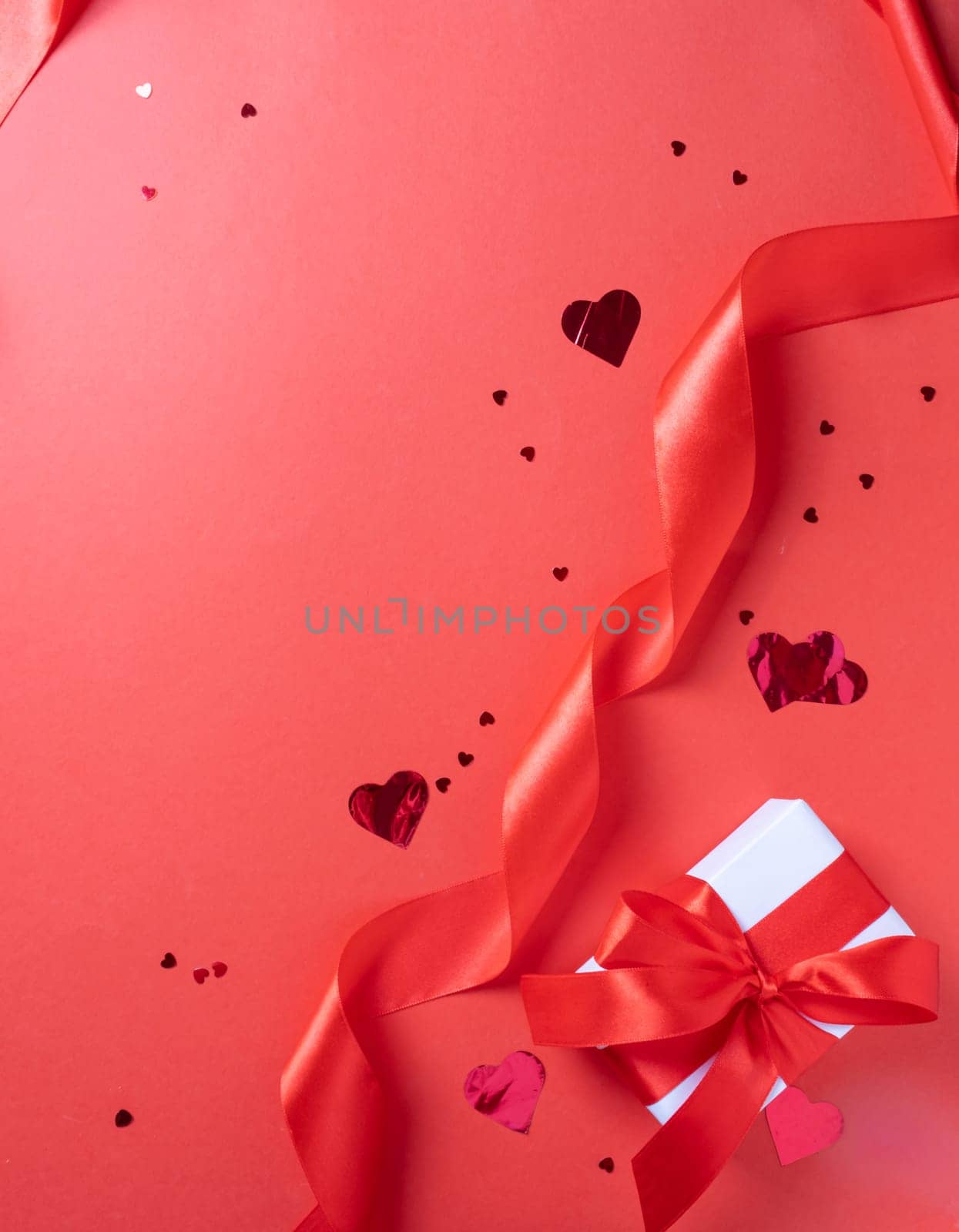 Valentines day. valentine red ribbons, confetti and gifts on red background