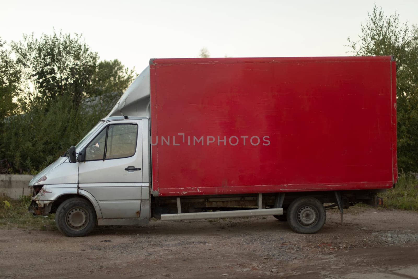 Red truck in parking lot. Red body. Machine for transportation of goods. Parking details in industrial area.